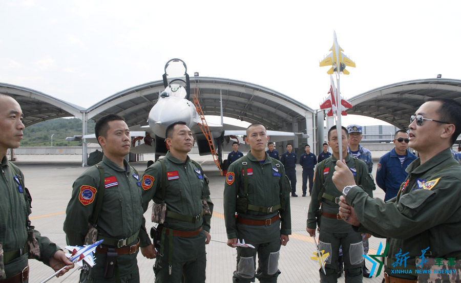 ↑海軍某艦載航空兵部隊部隊長戴明盟帶領飛行員進行地面模擬訓練。