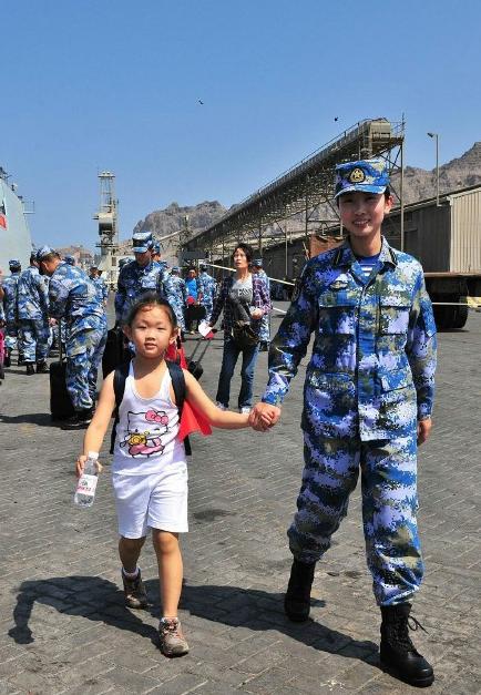 2015年3月，也門，海軍女戰士牽著一名小女孩的手準備登上軍艦。