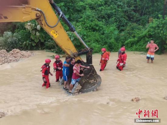 6月16日，因遭遇暴雨襲擊，廣西沿海多處發生嚴重內澇，居民被困。當地消防部門接到求助信息后，先后轉移被困的居民數十人。圖為利用鏟車運送被困居民。