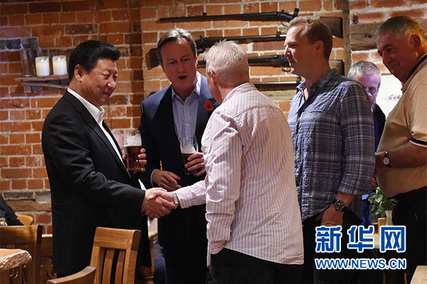 這是習(xí)近平與卡梅倫飲啤酒，并同當(dāng)?shù)孛癖娊徽劇Ｐ氯A社記者 饒愛民 攝